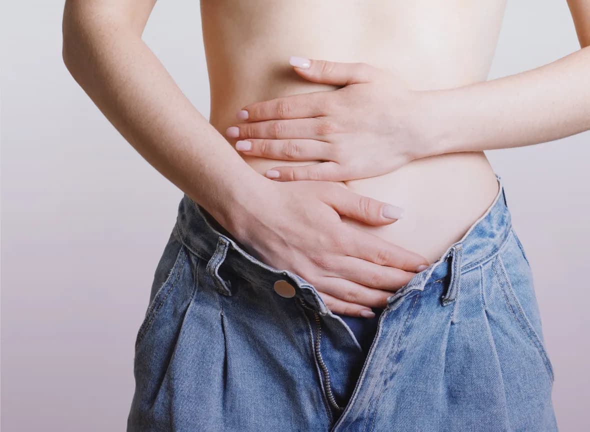 Woman with her hands on her lower abdomen